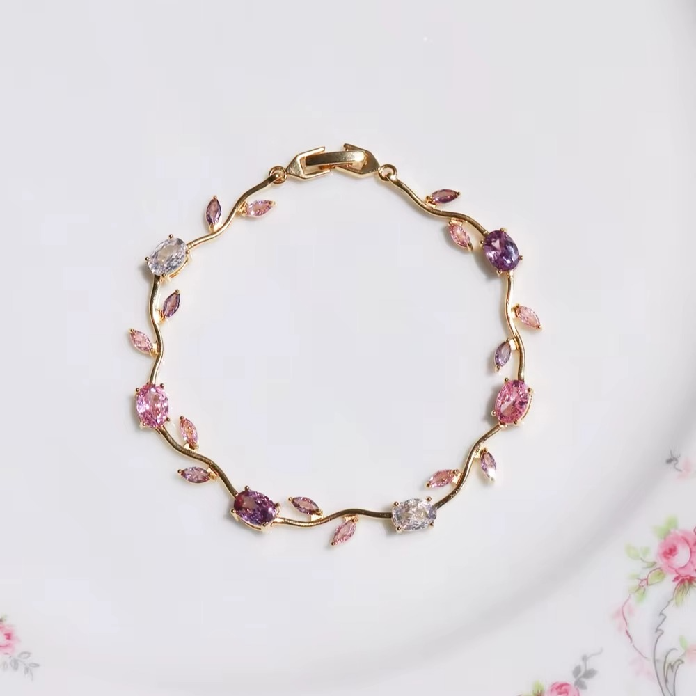 Another close-up of the gold floral bracelet on beige fabric surface