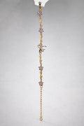 Gold bracelet with purple amethyst flowers and butterfly charm hanging vertically