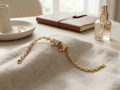 Gold plated bracelet with multicolor cubic zirconia stones on beige fabric