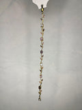 Close-up of elegant gold-tone bracelet with various cut pink and clear stones hanging vertically