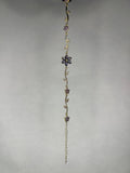 Close-up image of gold-plated flower vine bracelet with purple amethyst gems on a plain background