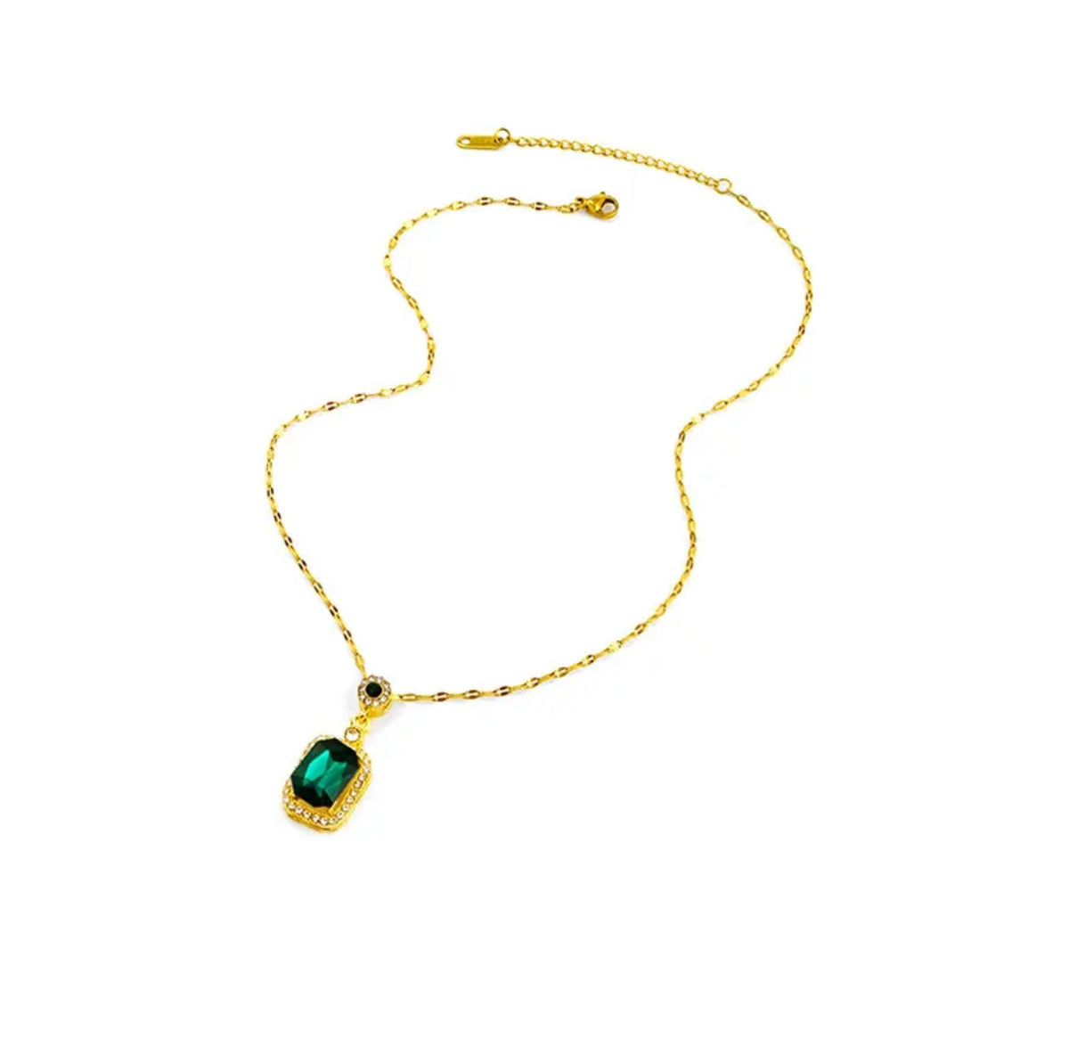Gold chain necklace with rectangular green gemstone pendant bordered by clear crystals on a white background